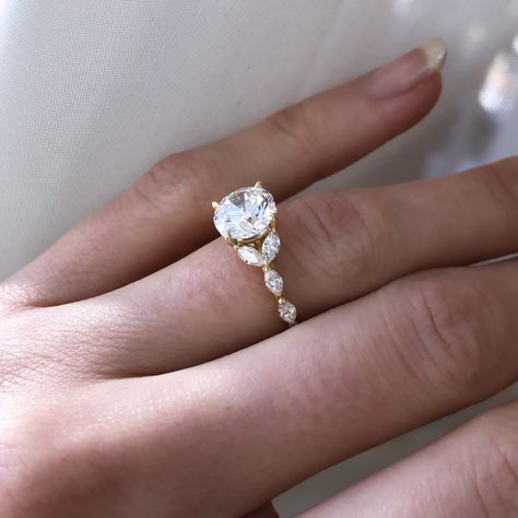 The Queen Marquise! ⁠ A ring worth her title! Shown with a gorgeous Round center stone, this unique setting can be recreated with any shape stone, and features two Marquise cut diamonds cradling the center stone on either side, and continuing on down the band in an elegant, super feminine design with it's undulating curves and endless sparkle! ⁠Brand new to our collection, we are delighted to show her off! Engagement Rings With Marquise Side Stones, Round With Marquise Side Stones, Marquise And Round Engagement Ring, Round Engagement Ring With Marquise Side Stones, Oval Ring With Marquise Side Stones, Unique Round Engagement Ring Settings, Round Diamond With Marquise Side Stones, Oval Engagement Ring With Marquise Side Stones, Marquise Side Stone Engagement Ring