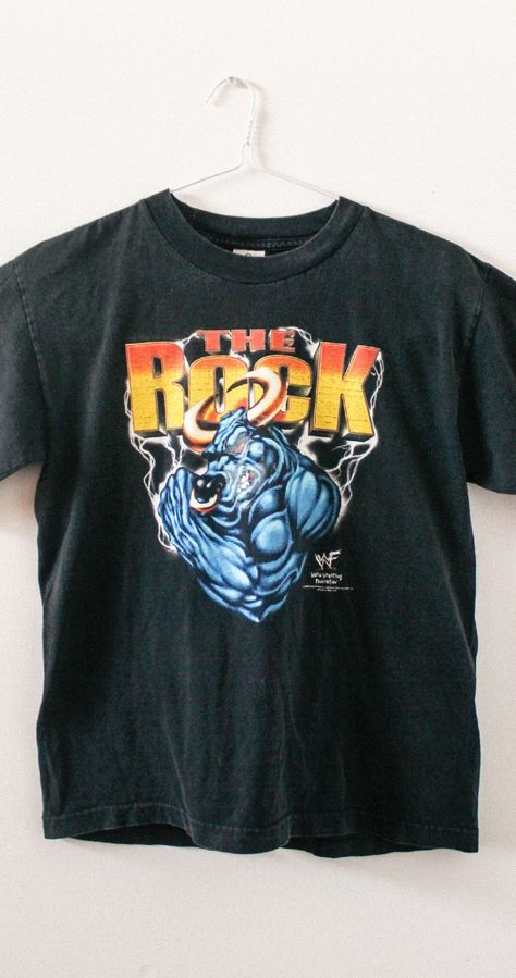 Early 2000s The Rock vintage tee. From Dwayne Johnson's days in the WWF on his way to becoming one of the most entertaining wrestlers of all time. Rep the People's Champ with this 2000 retro wrestling t-shirt from the WWF attitude era. SIZE: Large | LENGTH: 24 in | WIDTH: 18.5 in | CONDITION: good vintage with fading #wwe #therock #wwf Wwe Vintage Shirts, Wwf Attitude Era, Brahma Bull, Wrestling Shirt, Wwe Shirts, Wrestling Shirts, Rock Vintage, Vintage Graphic, Vintage Tee