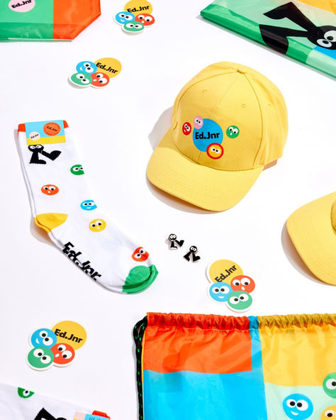 Our client @frasers_property_australia comissioned the cutest merch ever for one of their shopping centres. 🩵💛🧡💚 Ed.Jnr is a brand new kids club at Ed.Square Shopping Centre. The quality product suite features our Wonderpack, Watson Cap, Cheerful socks, Vinyl stickers and Cutie Pins - fully customised with Ed Jnr bright, fun branding. The purpose of this merch is to give out to new kids when they sign up to join the club. Score! Gen Z Merch, Studio Merch Photography, Cool Merchandise Ideas, Fun Merch Ideas, Stickers Photoshoot, Merch Socks, Merchandise Photography, Merch Ideas Products, Cap Merch