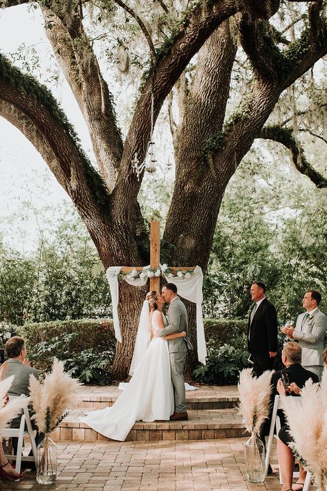 Under the grand oak tree, surrounded by love and nature's beauty. 🌳✨ This stunning ceremony with a cross adorned in white florals made for the perfect setting as these two said 'I do.' Such a serene and meaningful backdrop for a day they’ll never forget. 🤍

Venue: @mossestatesvenue
Photography: @monicagracephotography Wedding In Front Of Tree, Oak Tree Wedding Ceremony, Tree Wedding Ceremony, Oak Tree Wedding, Surrounded By Love, Halloween Movie Night, Wedding Altars, Halloween Movie, White Florals