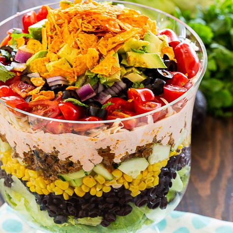 Layered Taco Salad has all the flavors of tacos piled on top of each other in a trifle dish. It's easy to make ahead for a potluck and it will feed a crowd.