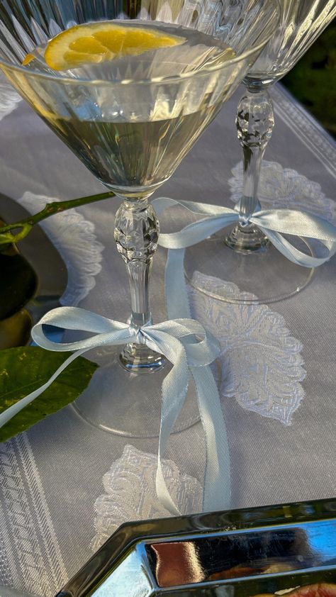 Silk baby blue ribbon bow on a martini glass at a dinner party Silk Theme Party, Cocktail Dinner Party Decor, Coquette Wedding Decor, Sandy Liang Wedding, Cottagecore Dinner Party, Drink Table Party, Coquette Dinner Party, Martini Bachelorette Party, Sandy Liang Aesthetic