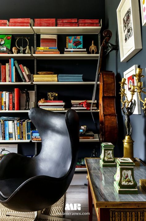 Dive into the depth of this cozy home office, artfully designed by Melanie Raines. A dark, richly-hued built-in bookcase offers ample space for books and home accents, creating a sophisticated backdrop for work or leisure reading. The iconic chair and vintage desk highlight the room's unique blend of modern and classic styles. This space is a testament to thoughtful design, where functionality meets elegance, perfect for those seeking inspiration for their own serene work sanctuary. Cozy Home Office, Iconic Chairs, Built In Bookcase, Modern Home Office, Vintage Desk, Cozy Home, Home Office Design, Interior Design Tips, Hotel Restaurant