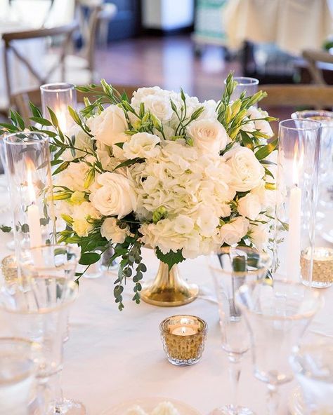 A white on white wedding with pops of green and gold will always be timeless and elegant. Las Vegas Wedding Planner @andreaeppolito Photo @stephensalazar Flowers @naakitifloral Short Wedding Centerpieces Elegant, Wedding Flower Arrangements Table Centerpiece Ideas, White And Green Centerpieces, White Candles Centerpiece, Wedding Ceremony Floral Arch, White Floral Centerpieces, Pink Green Wedding, Rustic Glam Wedding, 50th Wedding Anniversary Party