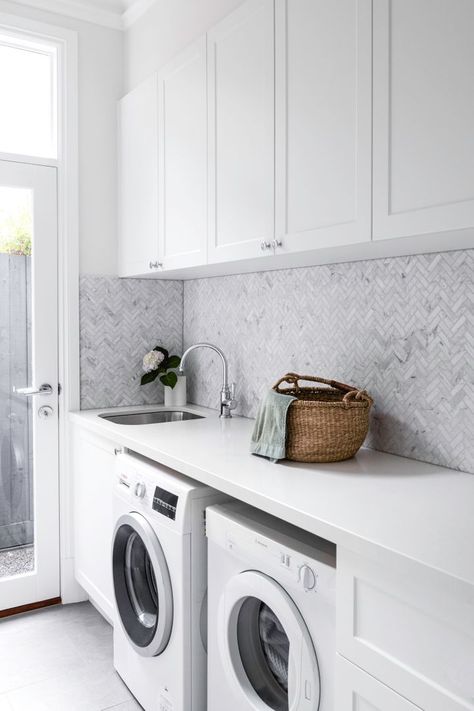 A Spacious Hamptons Home In Melbourne's Inner-East | Home Beautiful Magazine Australia Warm Oak Floors, Minimal Laundry Room, Hamptons Laundry, Minimal Laundry, Herringbone Splashback, Gray Herringbone Tile, Hamptons Style Laundry, Blue And Grey Bedding, Beveled Subway Tile