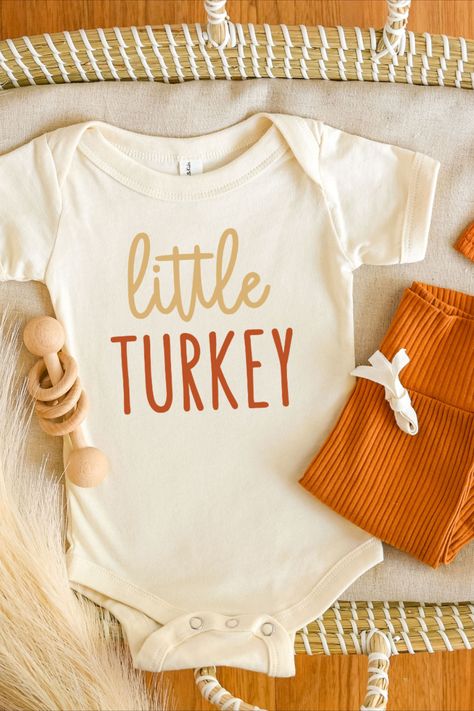 Little turkey cursive tan and rusty orange print on natural short sleeve unisex baby bodysuit laying flat with matching orange hat and pant set Toddler Shirt Svg, Fall Onesie, Babys First Thanksgiving, Thanksgiving Onesie, Rainbow Bodysuit, Thanksgiving Baby Outfits, Turkey Svg, Thanksgiving Tee, Svg Thanksgiving