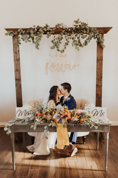 Our grey sweetheart table with our wood arch, bride added extra greenery & florals through florist Cross Behind Sweetheart Table, Wedding Arch Behind Sweetheart Table, Sweetheart Table Wood Backdrop, Sweetheart Table Wedding Indoor, Farmhouse Sweetheart Table Wedding, Wood Head Table Wedding, Sweetheart Table Arch, Wood Sweetheart Table, Wedding Sweetheart Table Backdrop