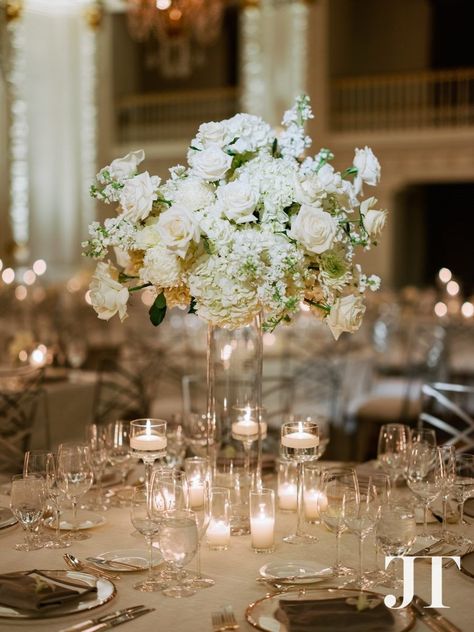 A subtle shape helped to make this tall all white floral centerpiece with no greenery stand out and have a slightly cool feel - designed by Seattle florist Flora Nova Design. Elevated wedding centerpiece on glass vase with lots of candles. Tall Arrangements, Ballroom Wedding Reception, Orchid White, White Inspiration, Wedding Reception Flowers, White Palette, Wedding Reception Centerpieces, Winter Wedding Flowers, Orchid Wedding