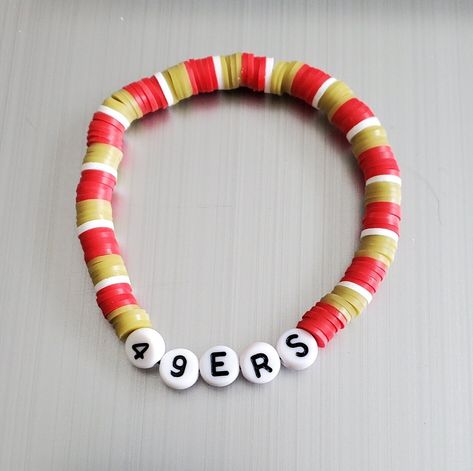 "This is a San Francisco 49ERS beaded bracelet in the 49ERS colors red and gold. A fun bracelet to wear alone or stacking with other bracelets. These bracelets are made with a sturdy elastic cord available in multiple sizes. Can be made with or without gold spacers. Size Guide: 5\" - Kids 6\" - Small 7\" - Average Adult 8\" - Large Thank you for visiting my store." 49ers Bracelet Ideas, Friendship Bracelet Stack Ideas, Football Team Bracelets, Nfl Clay Bead Bracelets, Football Bracelet Ideas, 49ers Bracelet, 49ers Colors, Bracelet Heishi, 49ers Team