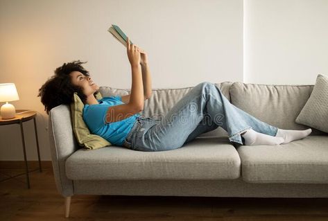 Rest, relax and study at home. Glad young black curly woman reading book, lying on sofa, enjoy spare time stock photography Woman Reading Book, Study At Home, Books To Read For Women, Black Curly, Home Study, Woman Reading, Young Black, Reading Book, Stock Photography