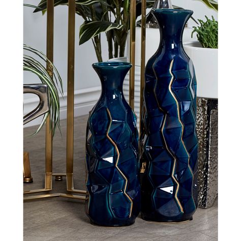 "Buy Blue Stoneware Modern Vase at Michaels. com. Add charm to your home with this unique vase. Add an innovative touch of abstract-inspired decoration into your eclectic, artistic, and modern living space with this splendidly smooth glazed denim blue vase! This rich and alluring home decor showcases a tall abstract-shaped edgy vase with a narrow neck, flannel-shaped mouth, and cracked golden line accents made of stoneware material. Its deep, denim blue tone and unique, irregular shape make it a Blue And Gold Living Room, Blue And Gold Bedroom, Navy Blue Decor, Blue Vases, Navy Blue Living Room, Gold Living, Blue Living Room Decor, Unique Vase, Gold Living Room