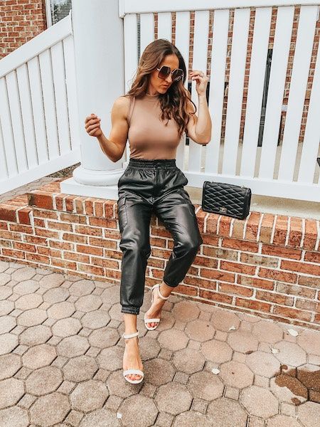 woman in faux leather joggers and bodysuit Faux Leather Jogger Pant, Leather Joggers Outfit Dressy, Outfits With Faux Leather Joggers, Bodysuit Joggers Outfit, Styling Leather Jogger Pants, Drawstring Leather Pants Outfit, Shoes With Leather Joggers, How To Wear Faux Leather Joggers, Faux Leather Jogger Outfit