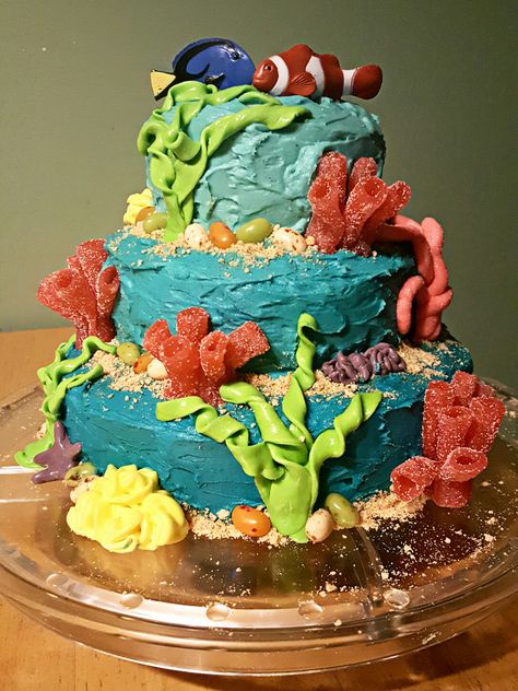 Coral reef cake I made for Littles' 3rd birthday. -Boxed blue velvet cake mix, homemade cinnamon vanilla buttercream, with coral and seaweed made from Laffy Taffy and sour straws, Jelly Bellys for rocks, and crushed graham crackers for sand. Toppers are the blue tang and clownfish from the Safari Coral Reef Toob. Blue Velvet Cakes, Laffy Taffy, Shake N Bake, Sea Cakes, Cinnamon Vanilla, Taffy, Birthday Box, Vanilla Buttercream, Animal Jokes