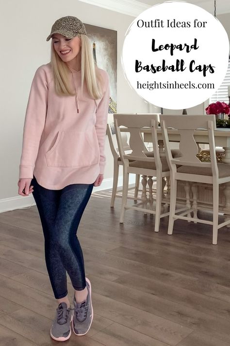 Woman in athletic wear and leopard baseball hat. Pink sweater. Black Leggings. Long Blonde Hair. Leopard Baseball Cap Style. Styling a baseball cap.