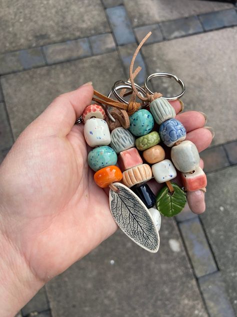 Constructed of handmade ceramic beads, these are such fun to make! Each keyring is made of 5 beads of different designs, textures and colours. All beads are handmade by me in my home studio, glazed and fired twice in my kiln. They are attached to the keyring with faux leather cord. All of these are different and you would be allocated one randomly (unless you specify a particular item). Please see my other keyring designs with hearts and leaves. Length approximately 12cm Diy Ceramic Beads, How To Make Ceramic Beads, Ceramic Bead Necklace, Ceramic Beads Handmade, Diy Clay Beads, Ceramic Keychain, Homemade Beads, Bead Keyring, Ceramic Jewerly