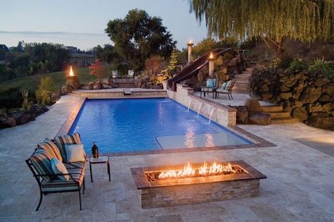 This poolscape features three separate bistro patio areas. Each nook offers a different view of the surrounding landscape and establishes a more intimate atmosphere. A firepit adds a cozy touch for summer nights spent al fresco. Photo courtesy of Rugged Class Waterfalls & Pools. Photography by Stephen K. Wolfe. Stone Pool Deck, Ideas De Piscina, Stone Deck, Rectangle Pool, Living Pool, Stone Pool, Small Swimming Pools, Pool Installation, Luxury Pools