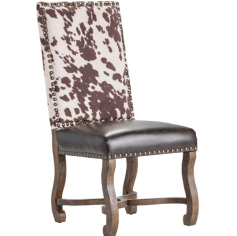 The Faux Cowhide & Leather Ranch Dining Chair has a brown leather seat adorned with gold metal nailheads for a pop of glamour. The flared legs have a distressed brown finish. A faux cowhide chair back brings the barnyard style while elevating it into a fashionable look. #southwest, #ranch, #sidechair, #diningchair Ranch Entrance, Coastal Chairs, French Country Dining Chairs, Cowhide Chair, Cane Back Chairs, Entrance Gate, Faux Cowhide, Ranch Decor, Ladder Back Chairs