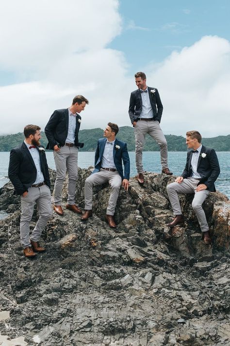 Groomsmen in Grey Chinos & Navy Blazers | Outdoor Coastal Wedding at Ohawini Bay in New Zealand with Natural Garden Party Reception | Miss Gen Photography Groomsmen Suits Beach Wedding, Outdoor Groomsmen Attire, Groomsman Beach Wedding Attire, Beach Wedding Navy, Coastal Weddings, Men Standing, Wedding Groomsmen Attire, Navy Blazers, Simple Beach Wedding