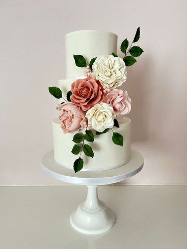 Three tier white wedding cake with dusky pink and ivory sugar roses and foliage Pink Wedding Cakes, Pink And Ivory Wedding, Ivory Wedding Cake, Three Tier Cake, Pink Wedding Theme, Sugar Rose, Pink Wedding Cake, Themed Wedding Cakes, Tier Cake