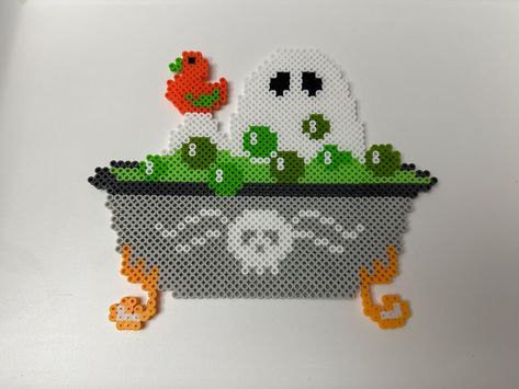 Ghost taking a bath in a green potion:) This ghost bathing in a spooky bath makes for the perfect decoration or gift just in time for Halloween! It looks great on walls and fridges! This ghost fella was hand crafted and ironed on both sides to ensure sturdiness. These beads are sturdy but will break if roughly handled! Each item is made to order, so items may appear different than pictured. Please don't hesitate to reach out if there are any questions  Thank you so much for your time and feel fr Perler Bead Patterns Spooky, Iron Beads Halloween, Perler Bead Inspiration, Iron Bead Art Ideas, Hama Beads Halloween Pattern, Halloween Fuse Beads, Spooky Perler Bead Patterns, Adult Perler Bead Patterns, Perler Bead Ghost