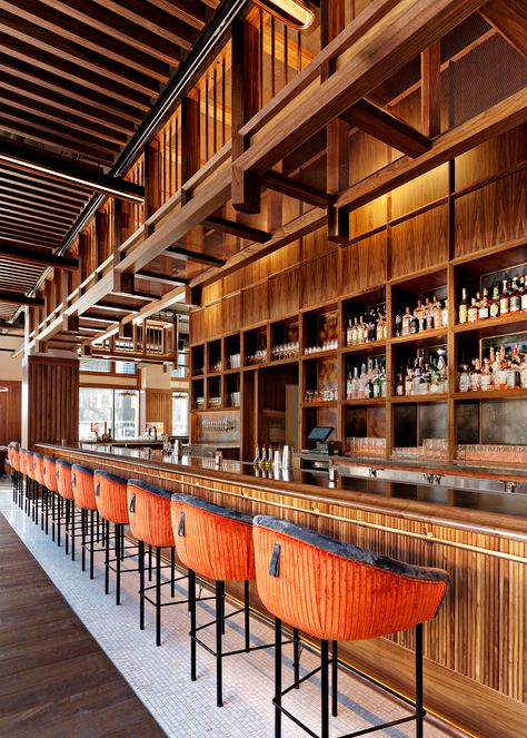 Large wood bar with built in shelves along the back. Wood overhang over back of bar, and stools with red and black upholstery Wood Overhang, Bar Overhang, Restaurant Counter Design, Back Bar Design, Wood Cafe, Bar Counter Design, Sport Bar, Restaurant Bar Stools, Pub Design