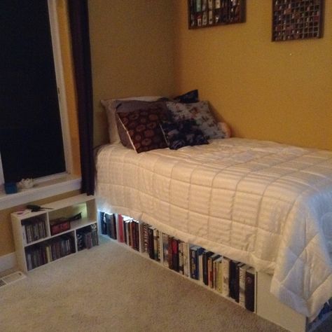 Book shelf Bed ! 5 three tier closet maid square shelf a turned on its sides a sheet of plywood then mattress and if you wish box spring and voila! Bookshelf bed Bed On Top Of Bookshelves, Bed With Bookshelf Underneath, Under Bed Bookshelf, Bookshelves Under Bed, Book Bed Frame, Book Shelf Beds, Bookshelf Above Bed Aesthetic, Books Under Bed, Book Shelf Bed Frame