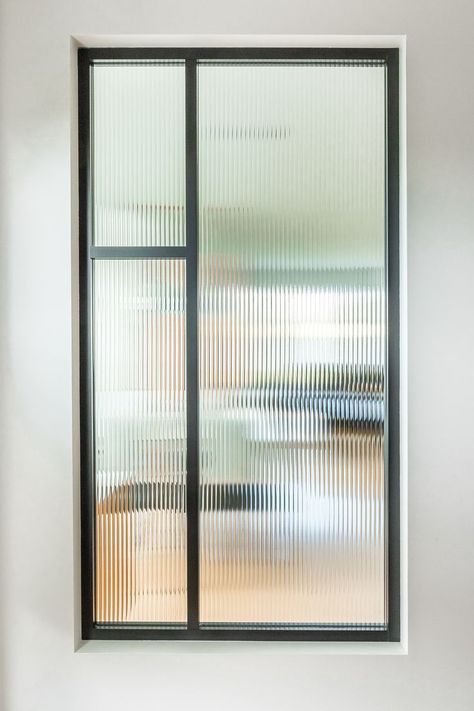 Interior window with fluted glass and black aluminum frame providing partial transparency between rooms. Fluted Glass Window, Interior Window, Fluted Glass, Glass Doors Interior, Swinging Doors, Interior Windows, Pivot Doors, Upstairs Bathrooms, Flute Glass