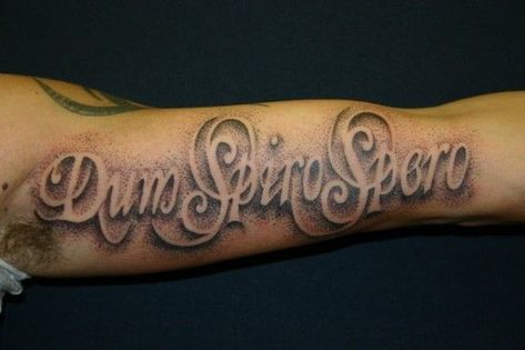 Tattoo Font Ideas for Men Choosing the right font style for your script tattoo as a man can be quite an uphill task. Whether you want a flashy design or a simple minimalistic look, you will be spoilt for choice with the thousands of options available. This tattoo says ‘Dum Spiro Spero’. It is written in a foreign language on the forearm and uses a cursive concept. The background is designed with dots to look spray painted. Tattoos written in other languages are a common practice. Tattoos Letters, Tattoo Writing Styles, Tato 3d, Font Tato, Letter Tattoos, Tattoo Font For Men, Tattoo Quotes For Men, Tattoo Lettering Design, Tattoo Lettering Styles