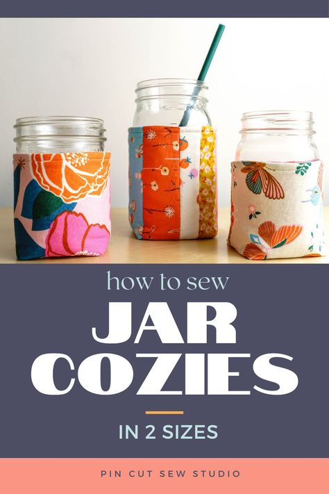 Three mason jars with colorful fabric cozies and text that reads "how to sew jar cozies in 2 sizes". Mason Jar Carrier Diy, Mug Coozie Sewing Pattern, Sewing Mason Jar Cover, Diy Kitchen Items To Sew, Mason Jar Cozy Sew, Can Cozy Sewing Pattern, Sew Teacher Gifts, Pin Cut Sew, Mason Jar Cozy Crochet