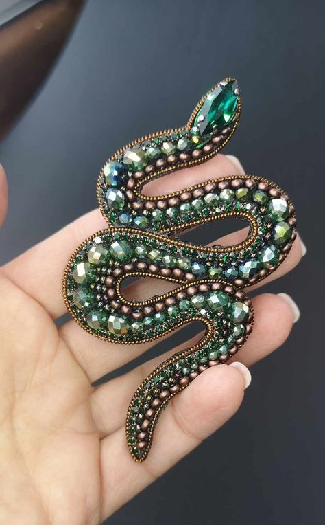 Wonderful Beaded Green Snake pin, 100% handmade jewelry brooch. Elegant snake pin, compact made in gold and brown colors. Composition: Rock-crystal, Swarovski pearls, seed beads, canitelle, amethyst, steel pin Dimentions: ~ 10 cm x 6 cm (4 x 2,4 inch) Original design, luxury quality. You will attract attention of everybody, wearing this delightful accessory.  The brooch can be pined on cardigan, scarf, coat or even on a bag. It composes perfectly with different kinds of textile, especially wool Embroidered Snake, Snake Brooch, Scarf Coat, Embroidered Brooch, Flower Pot Crafts, Green Snake, Jewelry Brooch, Animal Brooch, Brooch Jewelry