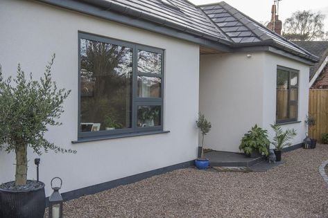 The cool anthracite grey windows stand out beautifully against the white render. #glazing #aluminium #windows #anthracitegrey #bungalow #bungalowrenovation #homeinspo #architecturaldesign #exterior #bungalow #exterior Rendered House Exterior Uk, House With Grey Windows, White Bungalow Exterior, Houses With Black Windows, Rendered House Exterior, Anthracite Grey Windows, Rendered House, Contemporary Bungalow, Rendered Houses