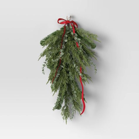 Get into the holiday spirit by decorating your home with this 28-Inch Mixed Greenery with Bow Hanging Christmas Artificial Swag from Wondershop™. Perfect for hanging on the front door, near the entrance or the living room mantel, this unlit swag features mixed greenery with red bow to bring a lovely look to any indoor setting. Plus, it's finished off with a string loop for easy hanging anywhere you please. Welcome to the Wondershop™. Holiday Window Wreath And Swag, Christmas Wreath With Bow On Windows, Hanging Wreath Tree Ceiling, Hang Wreath From Ceiling, Christmas Entryway Target, How Do I Hang Garland Around Door, Wreaths Kitchen Tall Cabinets, Swag For Wreath, Hanging Christmas Outdoor Baskets