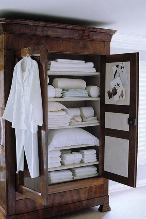 dark-brown-wood-armoire-remodelista Muebles Shabby Chic, White Linens, Wood Armoire, Linen Cupboard, 아파트 인테리어, غرفة ملابس, Massage Room, Hus Inspiration, Bed In Closet