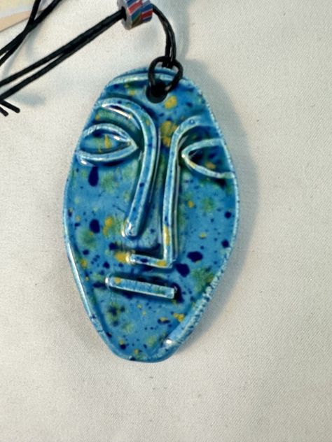 This beautiful pendant necklace is perfect for anyone looking for a unique and handcrafted piece of jewelry. Made by the skilled artisans at Blue River Pottery, this pendant features a stunning blue ceramic face that is sure to catch the eye. The necklace is expertly crafted and designed to be both stylish and comfortable to wear. Unique piece! Please see all photos and thanks for looking! Ceramic Jewelry Design, Pottery Face, Pottery Necklace, Ceramic Bead Jewelry, Ceramic Pendant Necklace, Clay Necklaces, Ceramic Face, Pottery Jewelry, Ceramic Jewellery