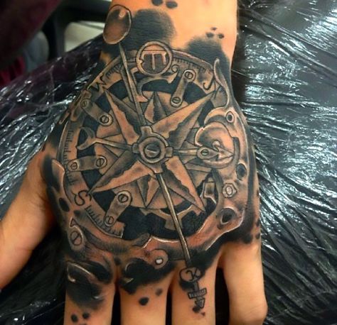 A nice tattoo of a steampunk compass inked in black and gray style on the hand. Steampunk Tattoo Design, Steampunk Hand, Compass Rose Tattoo, Steampunk Tattoo, Compass Tattoo Design, Nautical Tattoo, Urban Threads, Arrow Tattoos, Abstract Tattoo