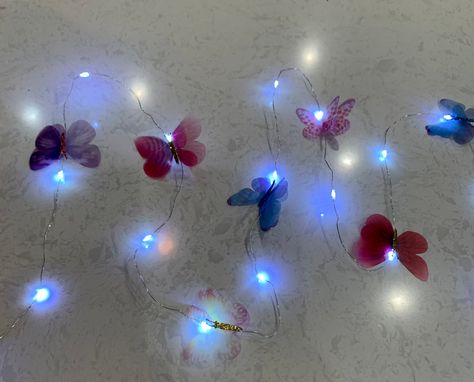 A decorative string of beautiful multi color sheer butterflies and 7 foot stunning LED string lights. These beautiful fairy lights are powered by AA batteries - not included, you can decorate anything you like. The butterflies can placed on railings or decorate your bedroom. Butterflies sheer material - suitable for indoor. Garland butterfly (3.0) Butterfly Party Decor, Palm Tree Lights, Pineapple Lights, Butterfly Party Decorations, Butterfly Garland, Butterfly Mirror, Led Fairy String Lights, Butterfly Lighting, 3d Butterfly Wall Stickers