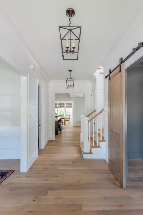 Charming coastal farmhouse style entryway featuring shiplap walls, white oak floors, sliding doors and hanging lanterns White Walls Hardwood Floors, Medium Light Hardwood Floors, Oak Floor White Walls, Oak Doors And Floors, Oak Floor And Doors, Coastal Living Room Flooring, White Walls Oak Floors, Blonde Wood Floors Living Room, Coastal Farmhouse Flooring