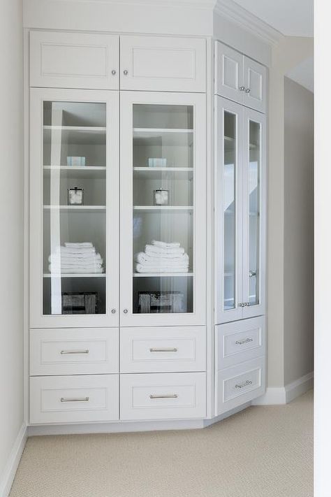 A curved, built-in linen cabinet is fitted with glass front cabinets flanked by white drawers adorned with polished nickel pulls and white overhead cabinets. Corner Linen Cabinet, Beautiful Bungalow, Bria Hammel Interiors, Built In China Cabinet, Bria Hammel, Linen Closets, Hall Cabinet, Curved Wall, Cabinets Design