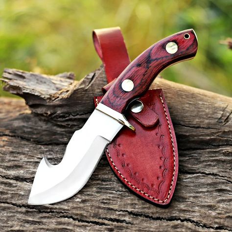 Handmade J2 Steel Gut Hook Knife With Wood Handle & High Quality Italian Style Leather Sheath - Best Gift For Him / Her. Overall Length: 10 Inches Blade Length: 5.00 Inches Handle Length: 5.00 Inches Blade Material: J2 Steel Handle Material: Wood, Brass Pins Hand Guard: Brass Italian Leather Sheath Blade is very sharp Full Tang Hand forged One of a kind Ready to be dispatched This superb design knife is hand forged and comes in a pouch which is free of cost to avoid damages. Features:... Best Chefs Knife, Brass Pins, Best Gifts For Him, Knife Collection, Custom Knife, Handmade Knives, Knife Making, Leather Sheath, High Carbon Steel