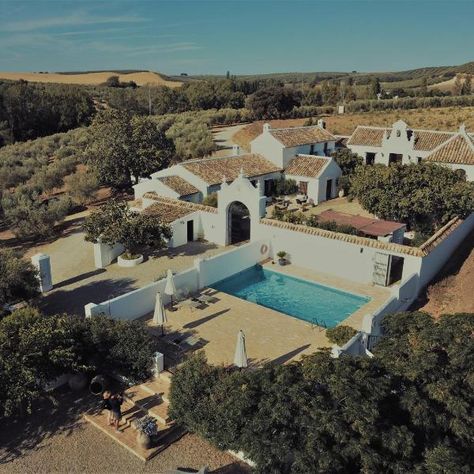 Set on beautiful grounds, this restored Andalusian farmhouse features spectacular views of the Alcalá Valley. Cortijo El Guarda preserves its original structure, offering a large courtyard and an outdoor swimming pool. Indoors, Cortijo El Guarda has a common kitchen and an honesty bar, as well as a library and a lounge with a fireplace and sofas. The house has white walls and exposed beams on the ceilings, featuring chestnut doors and rustic furniture. Each room is unique and individually decora Spanish Revival Architecture, Hotel Marbella, Hacienda Homes, Hacienda Style Homes, Courtyard House Plans, Mediterranean Style Homes, Best Bed, Casas Coloniales, Hacienda Style