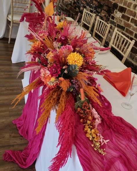 Orange and Pink Wedding Flowers. Set in the beautiful chamblesforth hall and grange. This style was mixed with dried and artificial flowers, and finished with bright pink and orange pampas grass. The table centerpieces were displayed on gold plinths from @kcoevents Added extras finished by the bride 😍 #smallbusinessyorkshire #yorkshiresmallbusiness #weddingcenterpieces #pinkorange #pinkorangewedding #pampascenterpiece #weddingdecor #selby #camblesforthhall #camblesforthhallandgrangewe... Pink Orange Burgundy Wedding, Pink Orange Fall Wedding, Purple Pink Orange Wedding, Hot Pink Orange Wedding, Orange And Pink Wedding Theme, Orange Wedding Centerpieces, Wedding Table Deco, Dried Wedding Flowers, Orange Wedding Themes