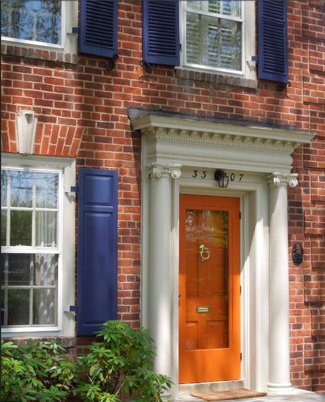 Orange Door + Blue Shutter {Color Combo}. Also LOVE the texture of the shrub (dwarf rhododendron?) Navy Shutters, Navy Door, Orange Brick Houses, Orange Front Doors, Best Front Door Colors, Brick Colonial, Best Front Doors, Orange Door, Black Shutters