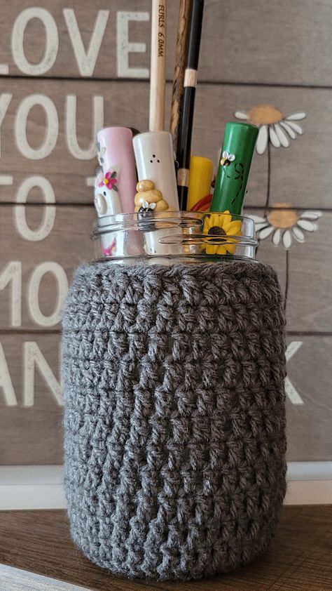 I designed this Mason Jar Cover Crochet Pattern to use to cover an old canning jar I had at home. I needed somewhere to put my Furls Tunisian Crochet Hooks but you can use them for so many purposes! These cozies make great, versatile gifts. This pattern is free and available in multiple sizes. #yarnspirations #caron #littlecrafties #pedrosplaques #crochetpattern #masonjar #furlscrochet #furlsinf721 Crochet Mason Jar, Crochet Jar Covers, Mason Jar Cozy, Quick Crochet Projects, Tunisian Crochet Hook, Crochet Ball, Cozy Crochet Patterns, Crochet Cozy, Small Mason Jars