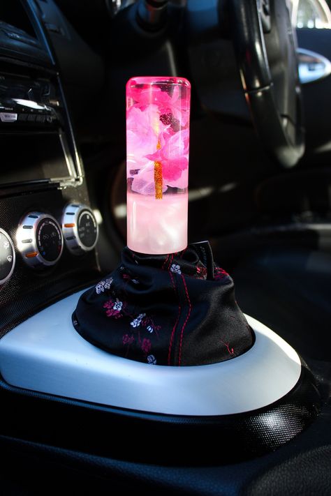 The Pink Sakura shift knob is from our series of the encased Shiftknobs, each shiftknob is hand crafted so no two shift knobs are ever the same. Giving you the opportunity to be unique from the crowd, each one is one of a kind.  This shiftknob features a gorgeous array of Sakura flowers complimented by a pearlescent base *Please note: If only the car model and transmission is specified we will thread it to what is commonly used, however as the thread size for each car can be different the buyer Flower Shift Knob, Car Makeover, Smart Car Accessories, Cool Car Gadgets, Amazon Accessories, Boho Car Accessories, Car Life Hacks, Must Have Car Accessories, Maximum Ride