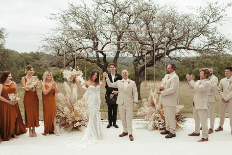 Shelby + Kyle's terracotta and rust modern boho wedding at Mae's Ridge in Texas Hill Country featured pampas grass wedding decor, dried florals, rust ceremony and reception details, and lots of boho vibes! Bride wearing sleeveless boho lace wedding dress, groom wearing tan suit, bridesmaids wearing rust long dresses. Pampas grass ceremony decor Florals \\ Good Seed Floral Photo \\ Brooke Taelor Photo Venue \\ Mae's Ridge Gown \\ Lover’s Society Tan And Rust Groomsmen, Terracotta And Pampas Grass Wedding, Tan Suit Fall Wedding, Terracotta And Khaki Wedding, July Boho Wedding, Tan Groomsmen Suits With Terracotta, Boho Wedding Bride And Groom, Rust And Tan Wedding Decor, Boho Terracotta Wedding Groomsmen