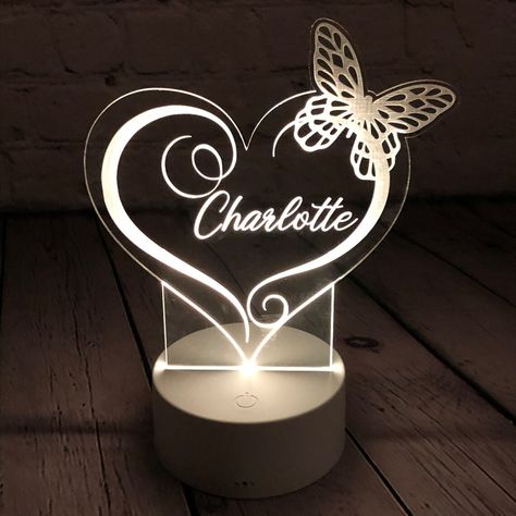 This led lamp or night light with heart and butterfly can be personalized to have a name of your choice engraved in it and will look especially beautiful at night glowing in one of the 15 colors of your choice...or press fade or strobe to have it go through a rainbow of colors. The acrylic is laser cut into a heart shape and the top wings of the butterfly (due to the top wings being a smaller area of acrylic, the light is slightly more dim on those wings). The designs within that are laser engra Name Lamp, Night Table Lamps, Funny Valentines Gifts, 3d Led Lamp, Lamp 3d, Lamp Night, Night Table, Name Gifts, Night Lamps