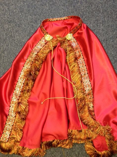 Queen or King's Cape: Cut out half a circle using satin type fabric. Glue gun old fashion drapery trim and other gold trim. Add gold rope to tie on. King Cape Diy, Prince Party Theme, King Cape, Scottish Costume, Free Masons, Career Costumes, Diy Cape, Drapery Trim, Prince Party