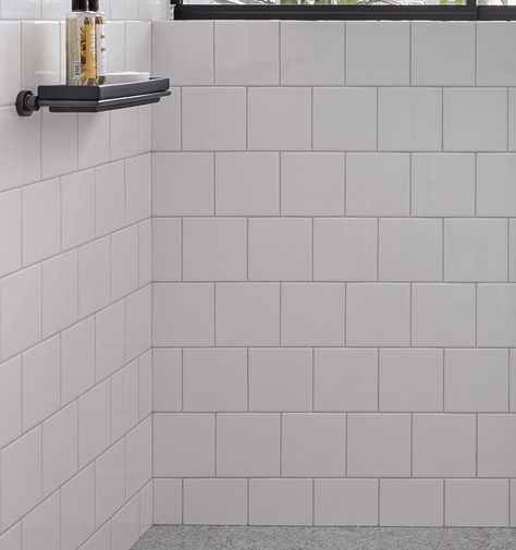 In this modern bathroom, floor-to-ceiling white tiles cover the walls, measure in at 15x15cm, have matching white grout. #SquareWhiteTiles #SquareTiles #BathroomIdeas White Grout, Bathroom Layouts, White Bathroom Tiles, Bathroom Lights, Bright Bathroom, Tile Covers, Natural Stone Flooring, Grey Granite, Material Palette