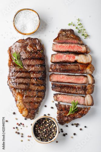 Stock Image: Two grilled marbled beef steaks striploin with spices isolated on white background, top view