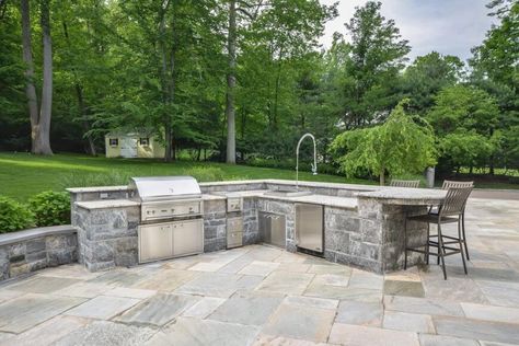 Here's another free standing outdoor kitchen, with large L-shaped stone island holding granite countertops. Full setup includes sink, mini fridge, grill, and barstool seating. Bbq Areas, Granite Bathroom Countertops, Stone Bbq, Corian Countertops, Outdoor Kitchen Countertops, Shaped Kitchen, Outdoor Kitchen Ideas, Bbq Island, Concrete Fireplace